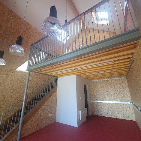 Interior mezzanine of a Folkestone art hut in Tontine Street with large ceiling hanging lights and wood and metal detail