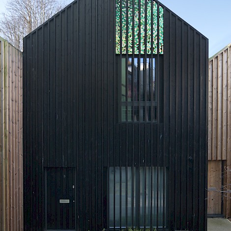 Close up of a single building in dark wood cladding with window detail